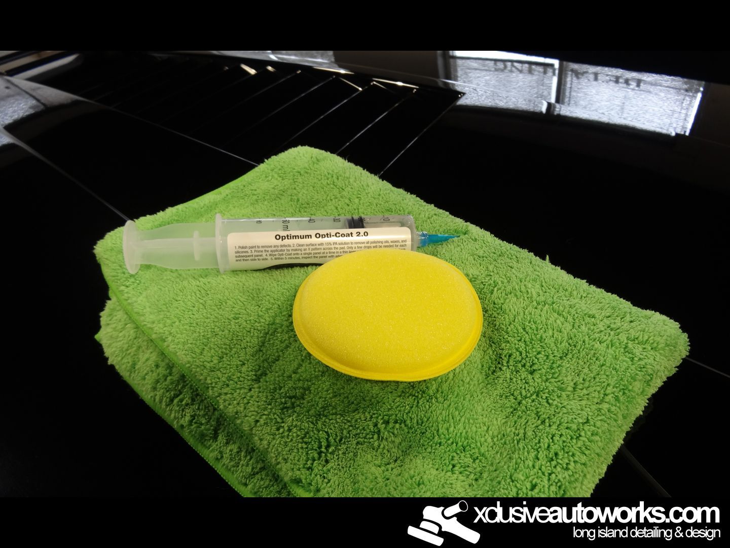 A green towel with a yellow sponge and a syringe on it