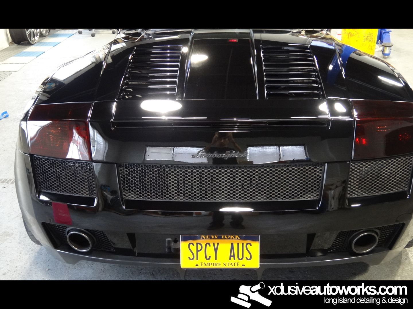 A black sports car with a yellow license plate that says spcy aus