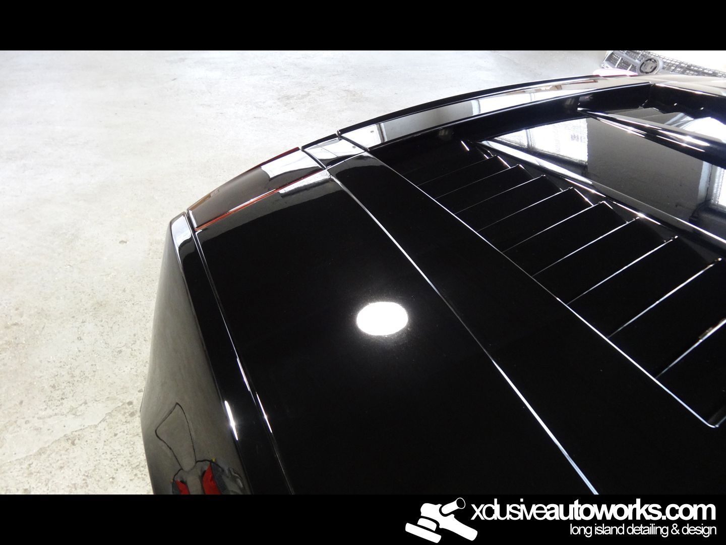 A black car with the website xdusveautoworks.com on the bottom