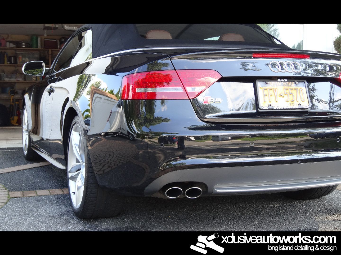 A black audi convertible is parked in a garage