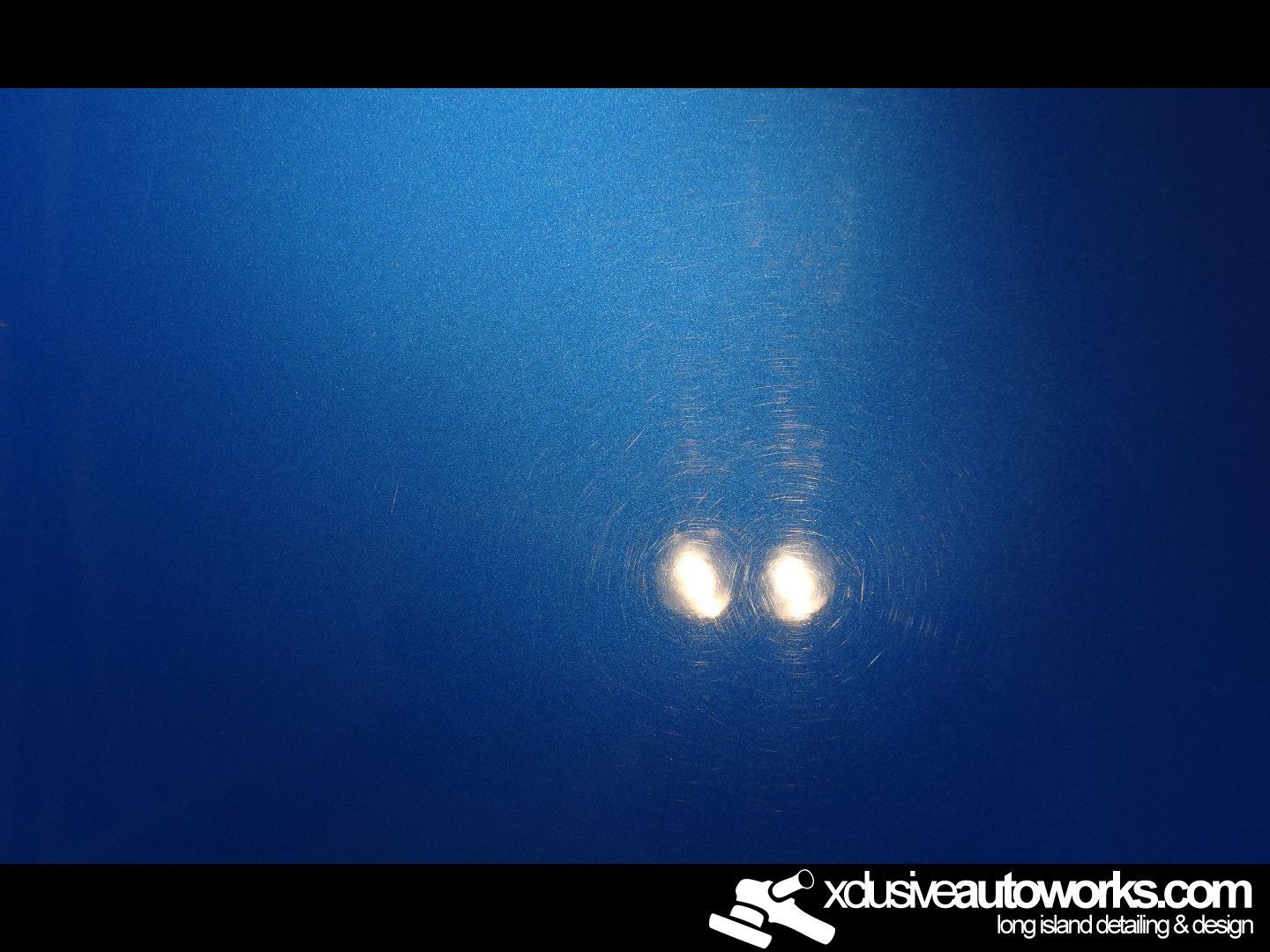 A close up of a blue surface with xclusiveautoworks.com written on the bottom