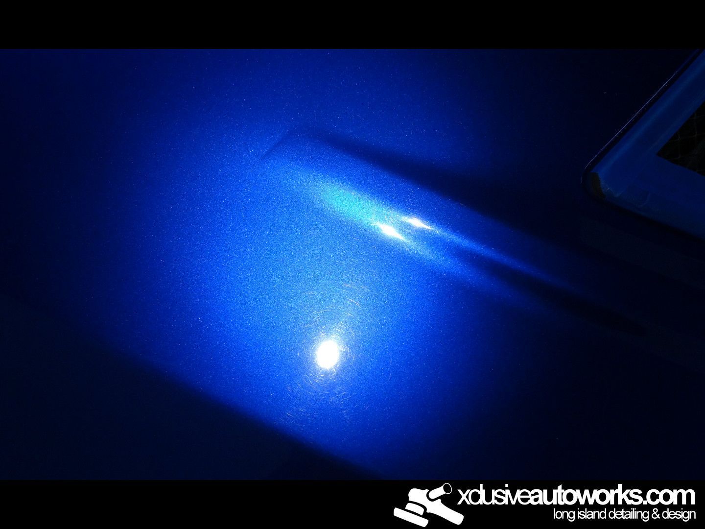 A close up of a blue car with a light coming out of it.