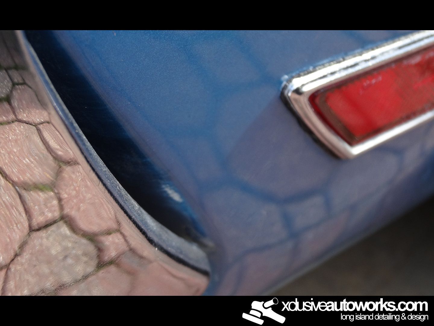 A close up of a blue car with xdusveautoworks.com written on the bottom