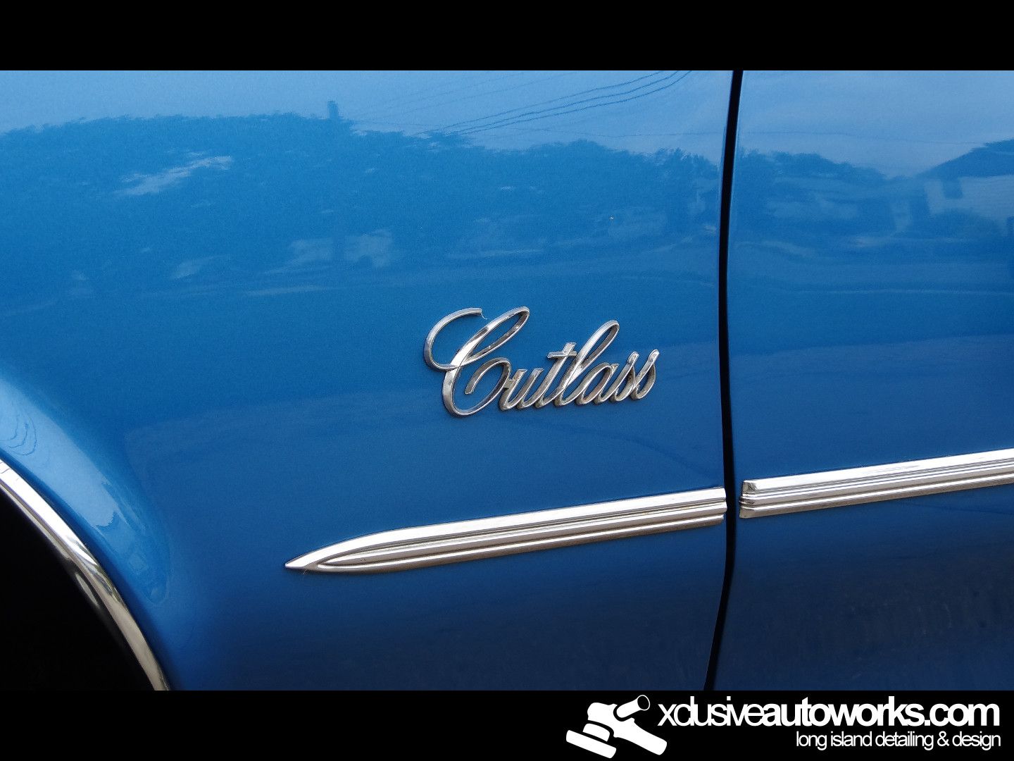 A blue car with the word cutlass on the side