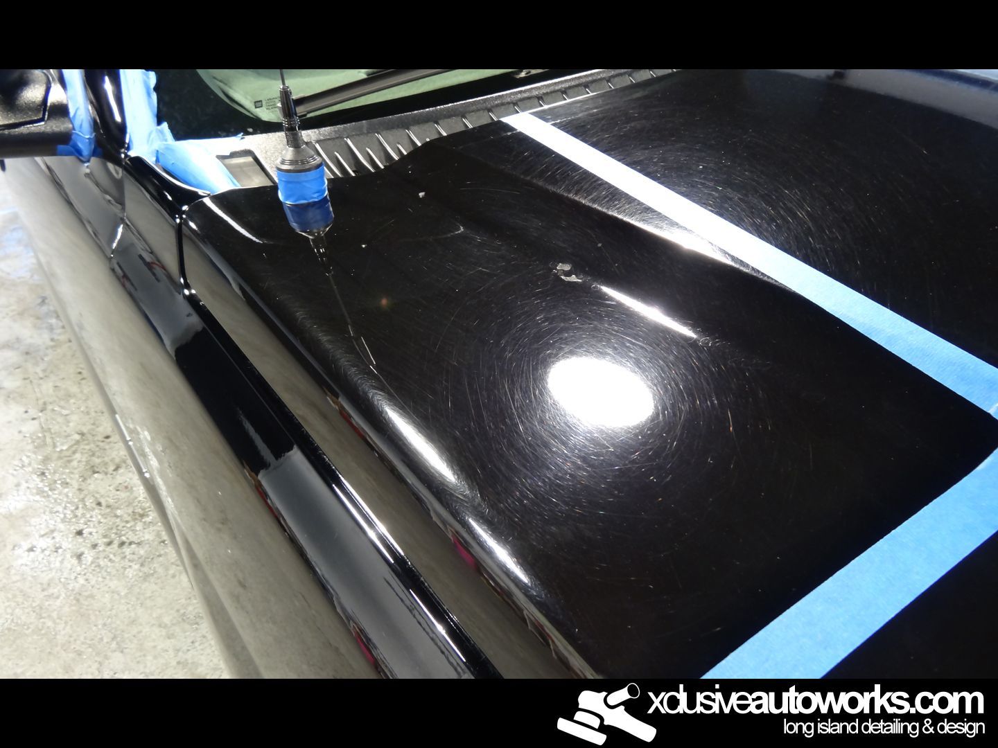 A close up of a black car with the website xdusveautoworks.com at the bottom