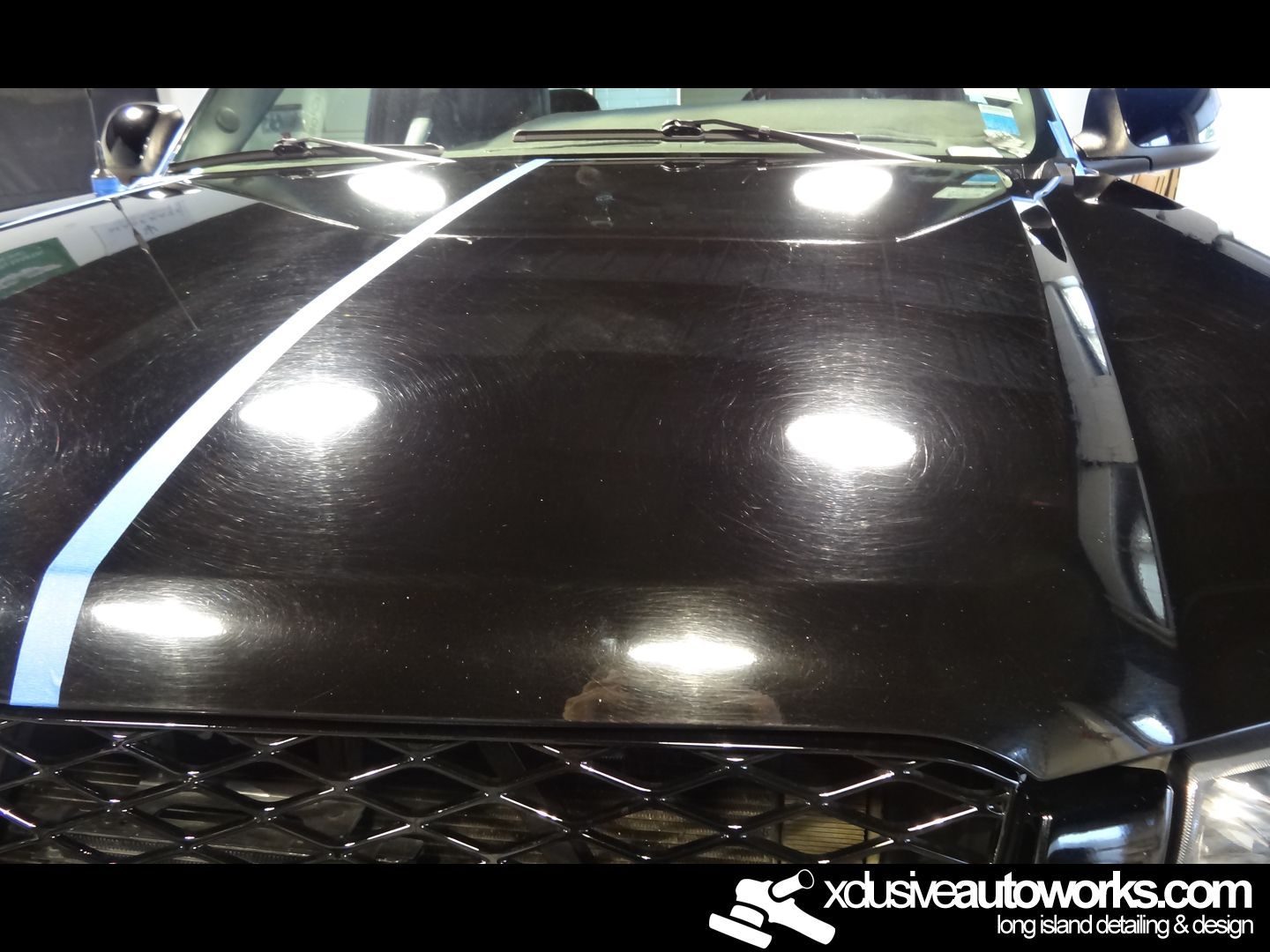 A close up of a black car with xdusveautoworks.com written on the bottom