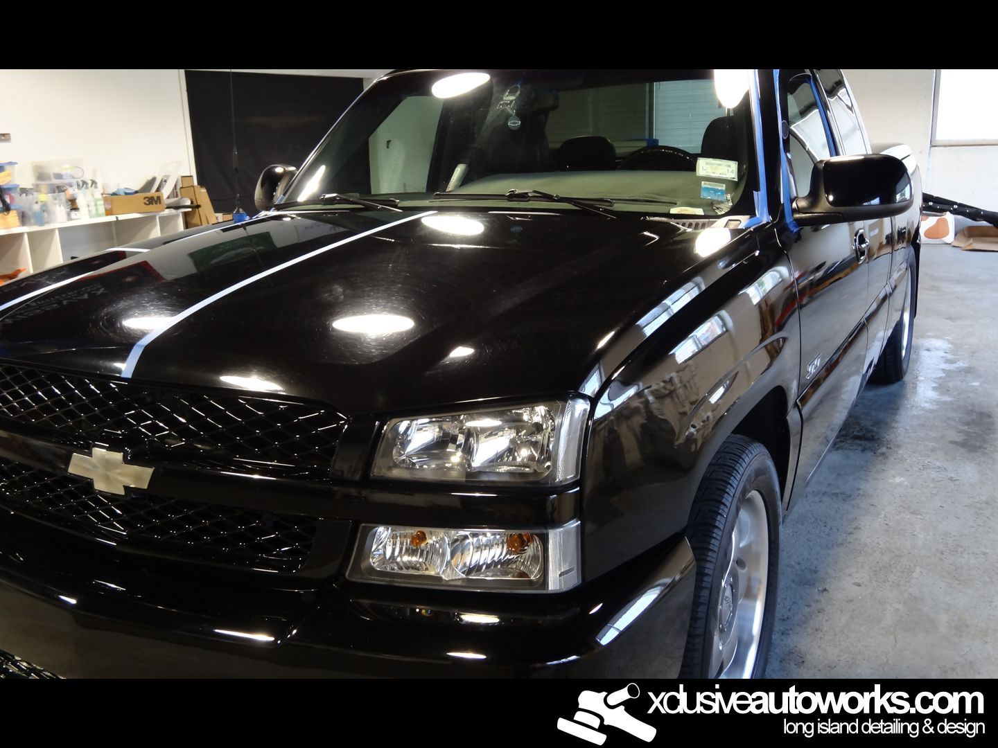 A black chevrolet truck is parked in a garage