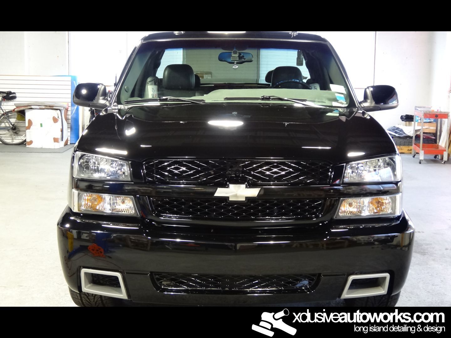 A black chevrolet truck is parked in a garage
