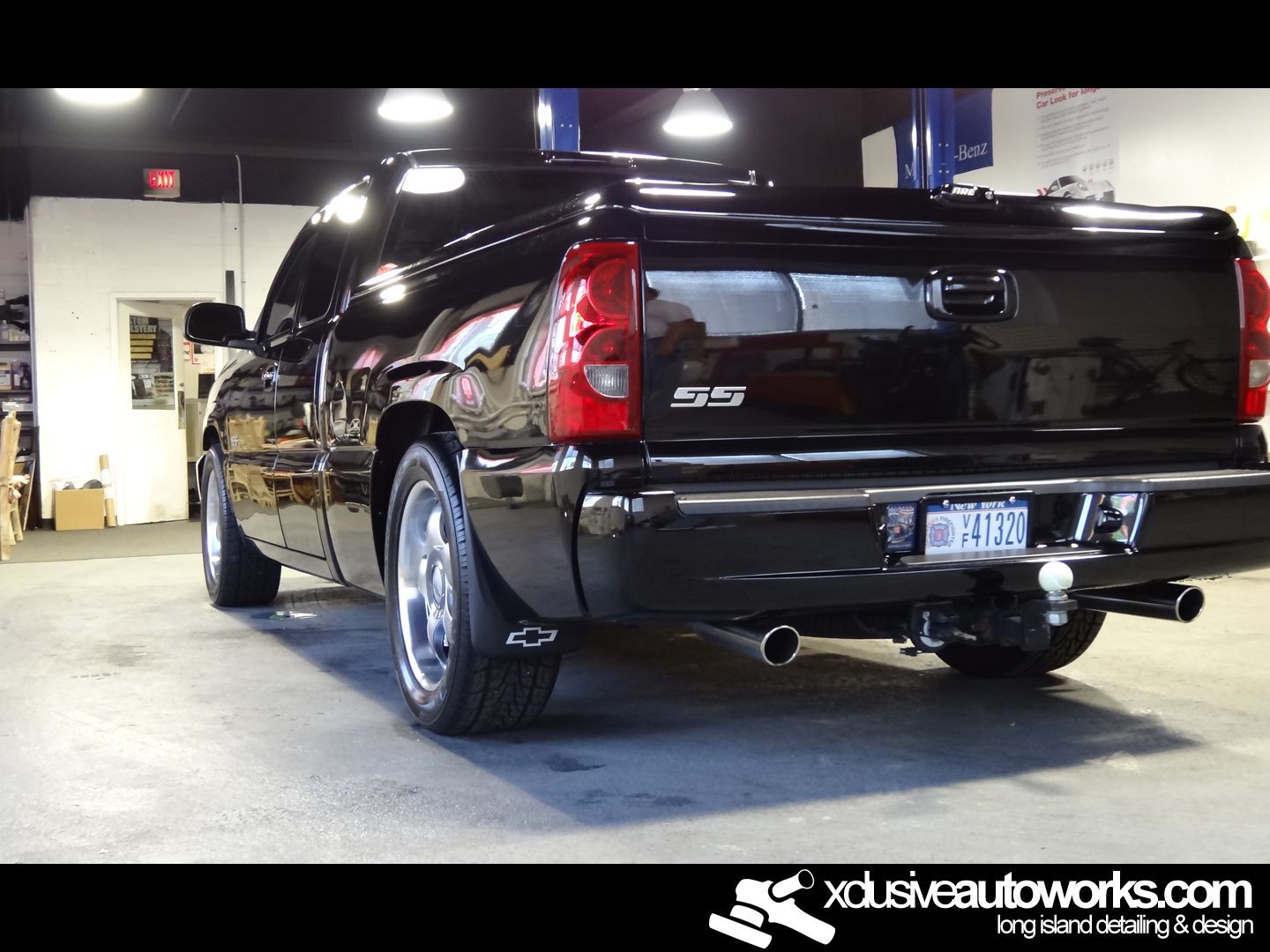 A black sd truck is parked in a garage