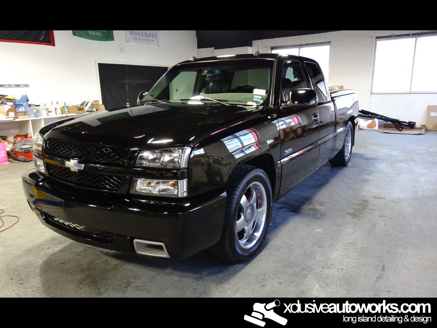 A black chevrolet truck is parked in a garage