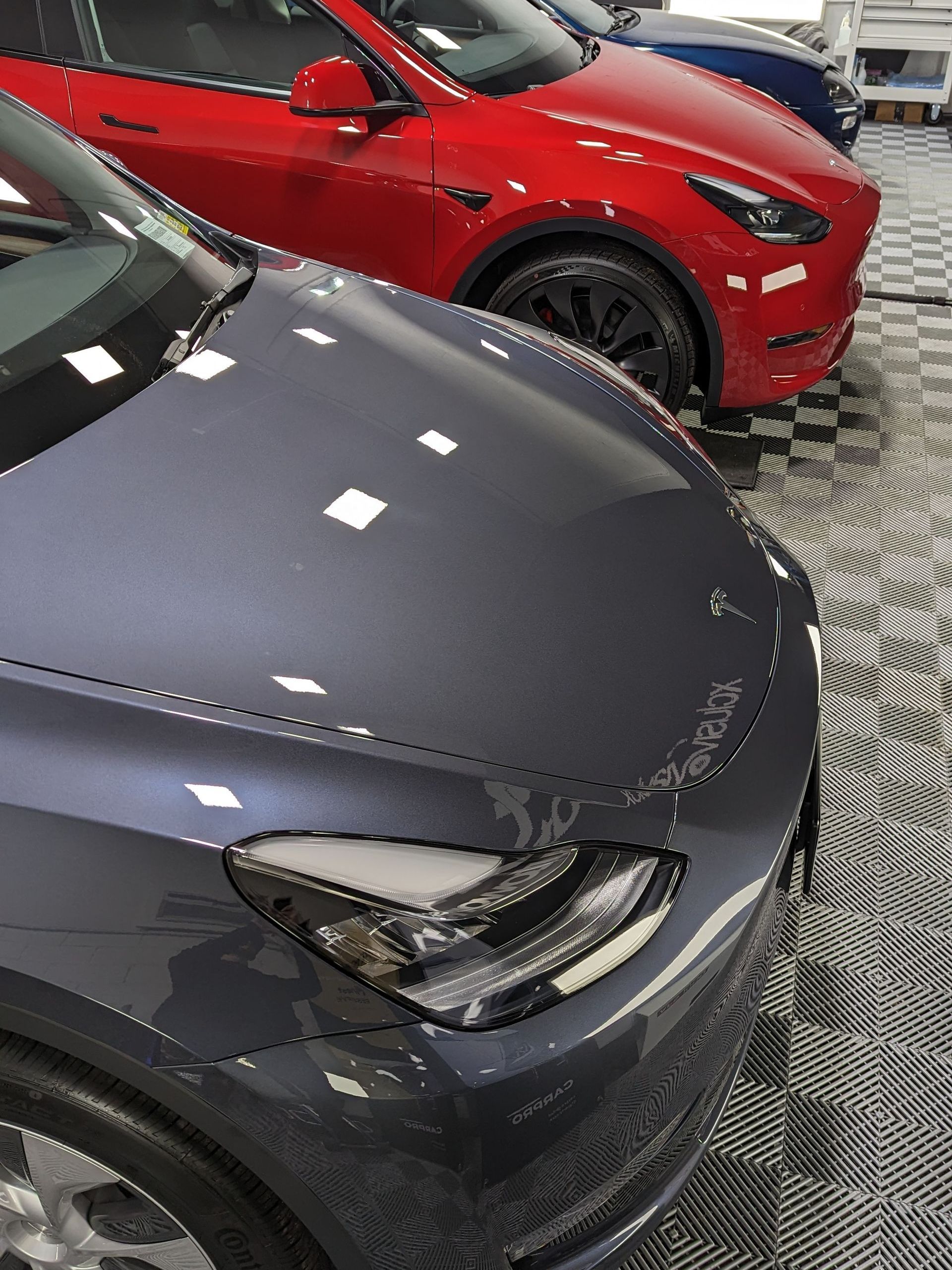 A row of tesla cars are parked in a showroom