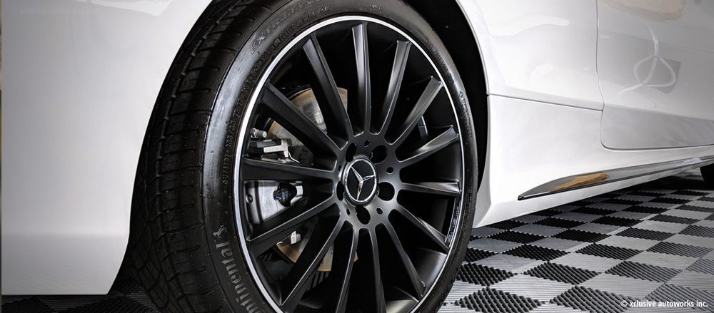 A close up of a car wheel on a checkered floor