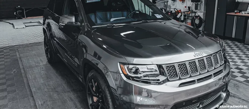 A jeep grand cherokee is parked in a garage.