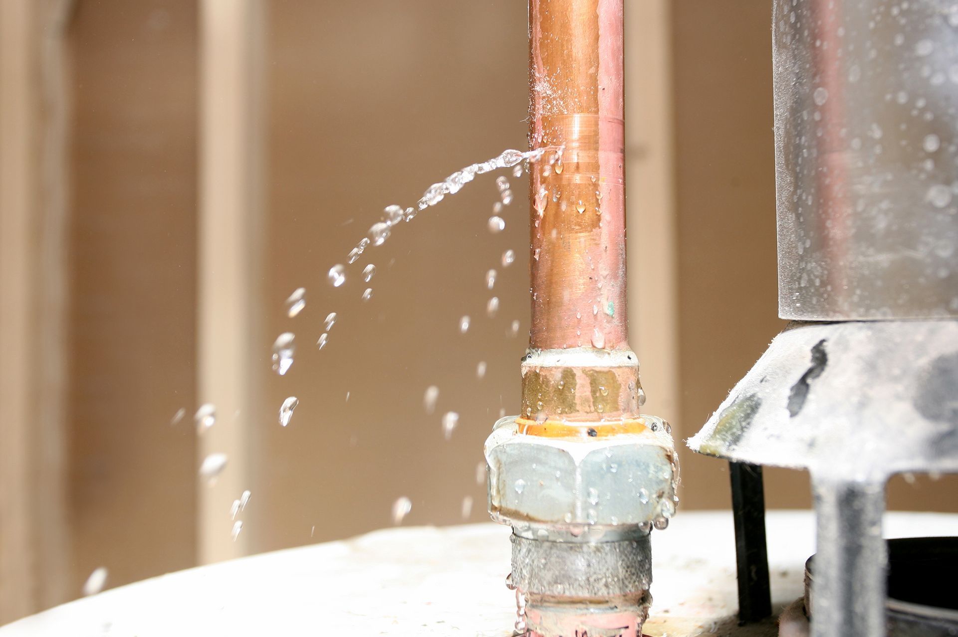 Water is leaking out of a copper pipe.