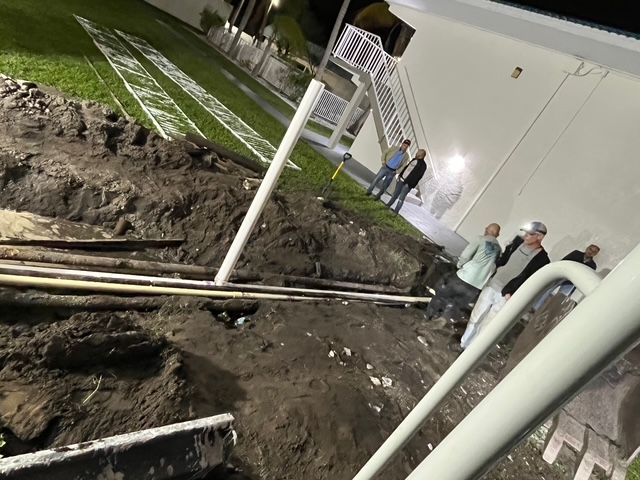 A group of people standing around a hole in the ground