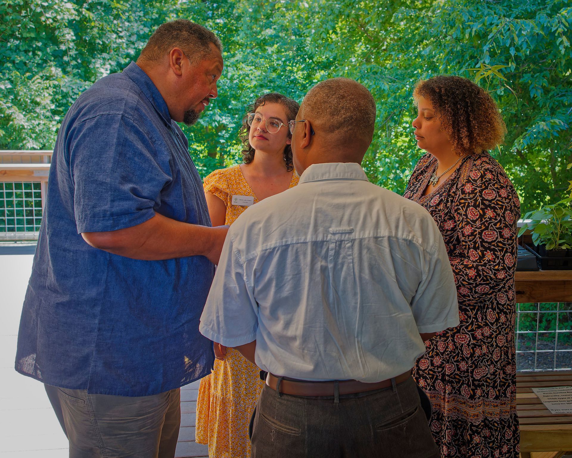 A group of people are standing on a deck talking to each other