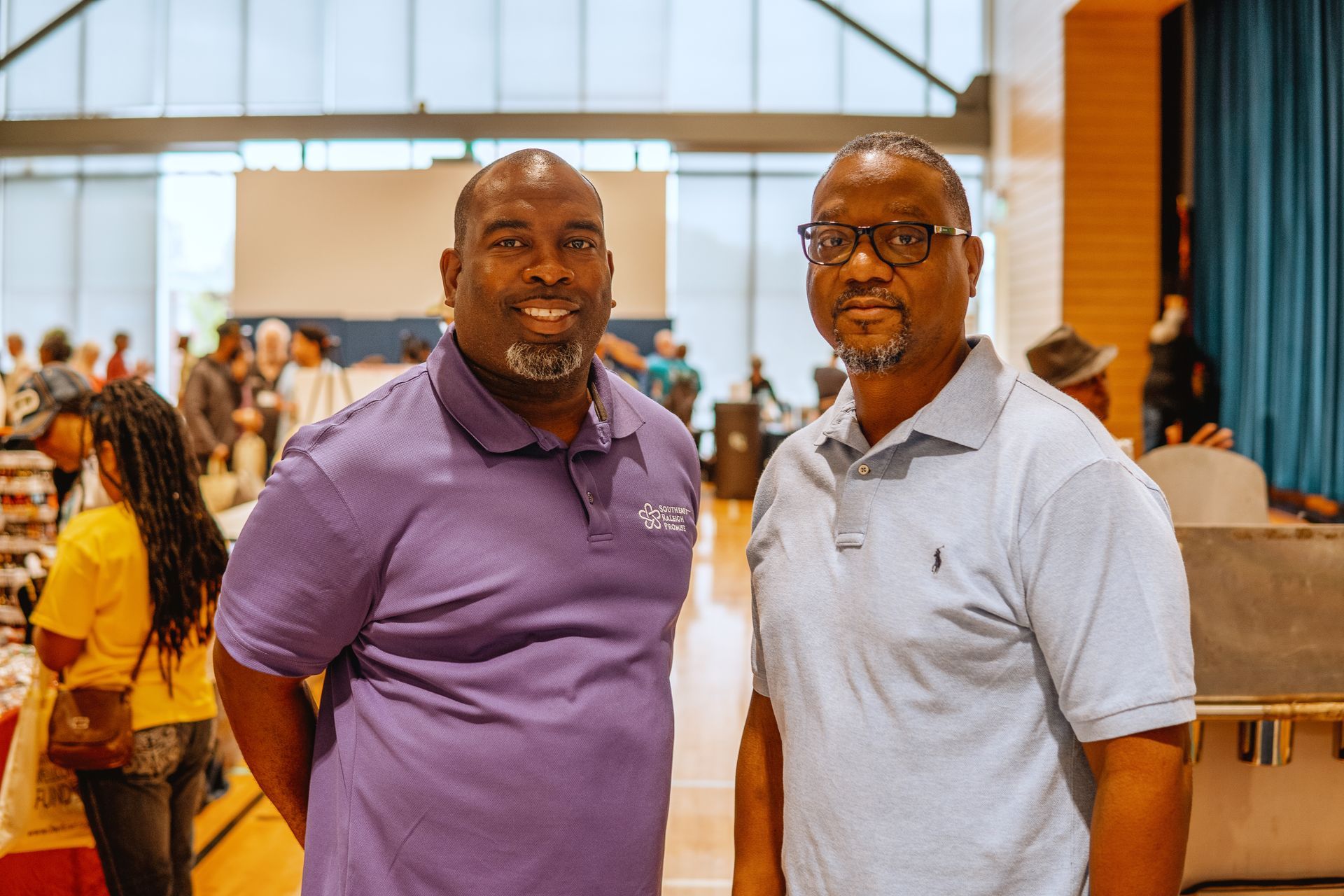 Two men are standing next to each other in a room.