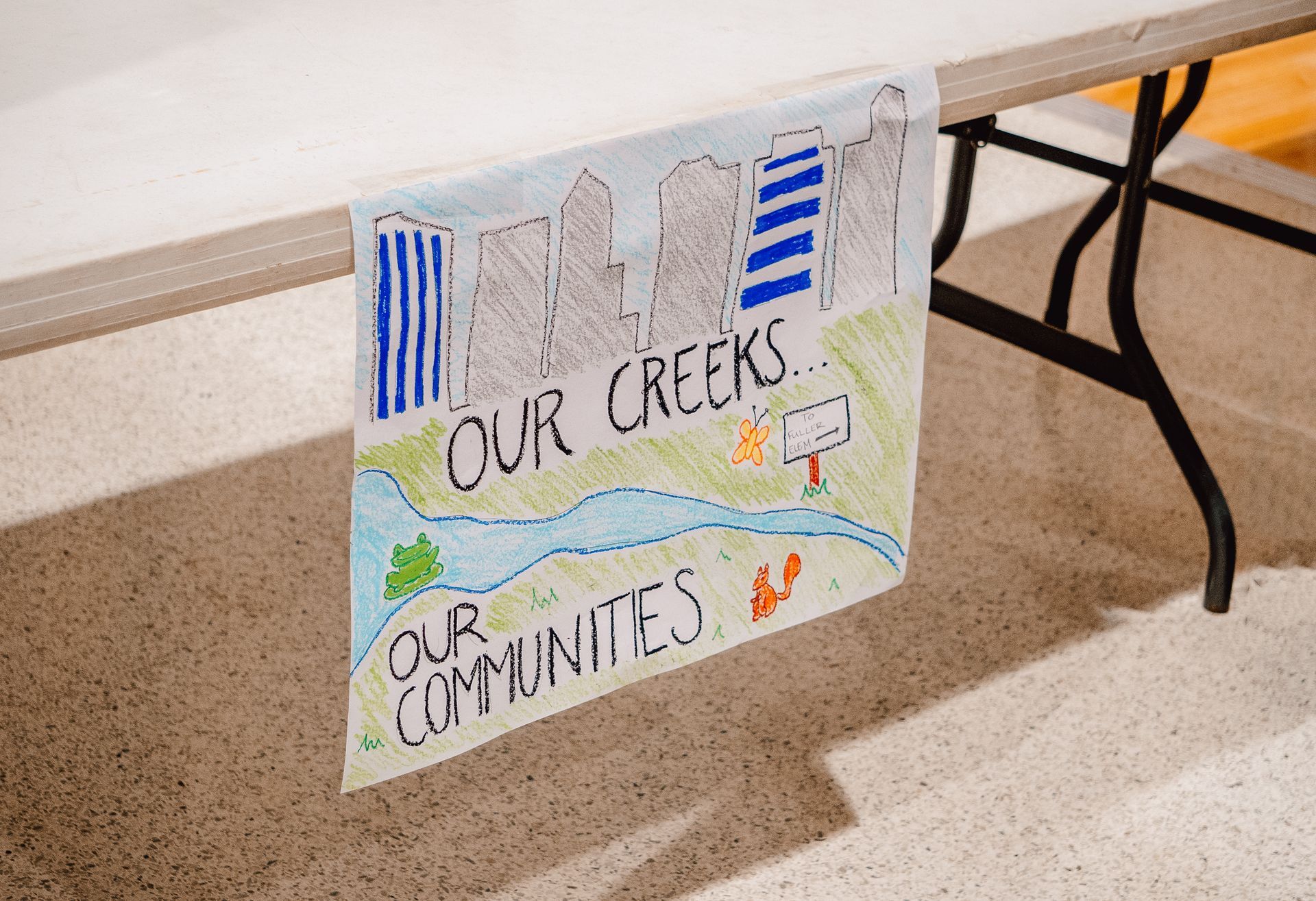 A sign on a table that says our creek our communities