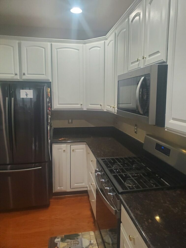 A kitchen with stainless steel appliances and white cabinets.