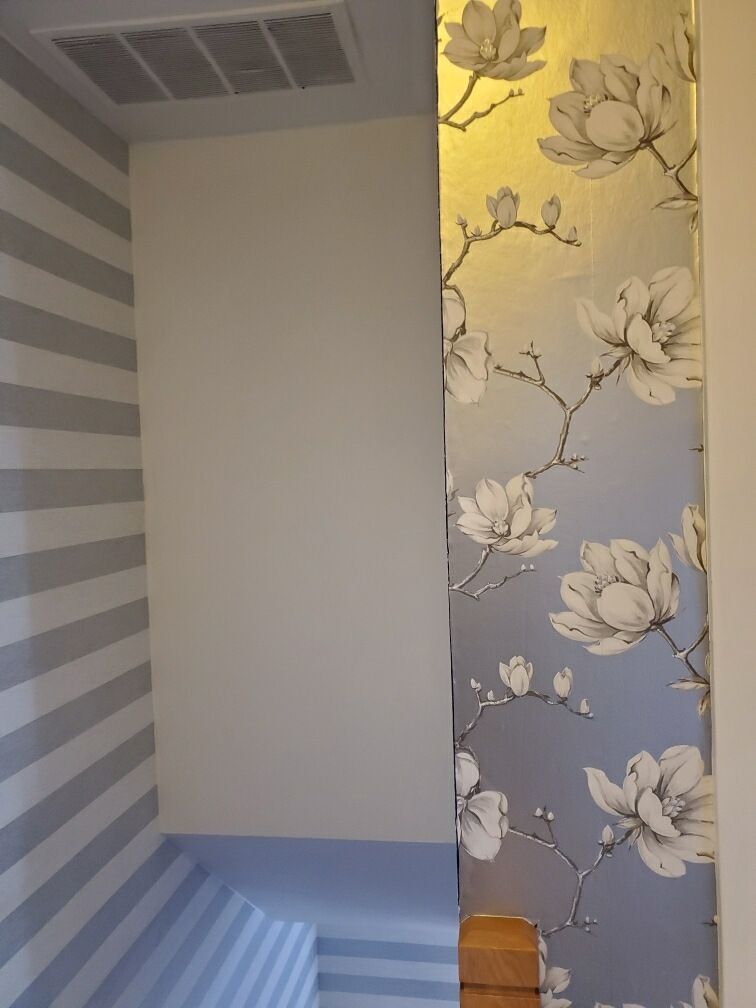 A room with a floral wallpaper on the wall