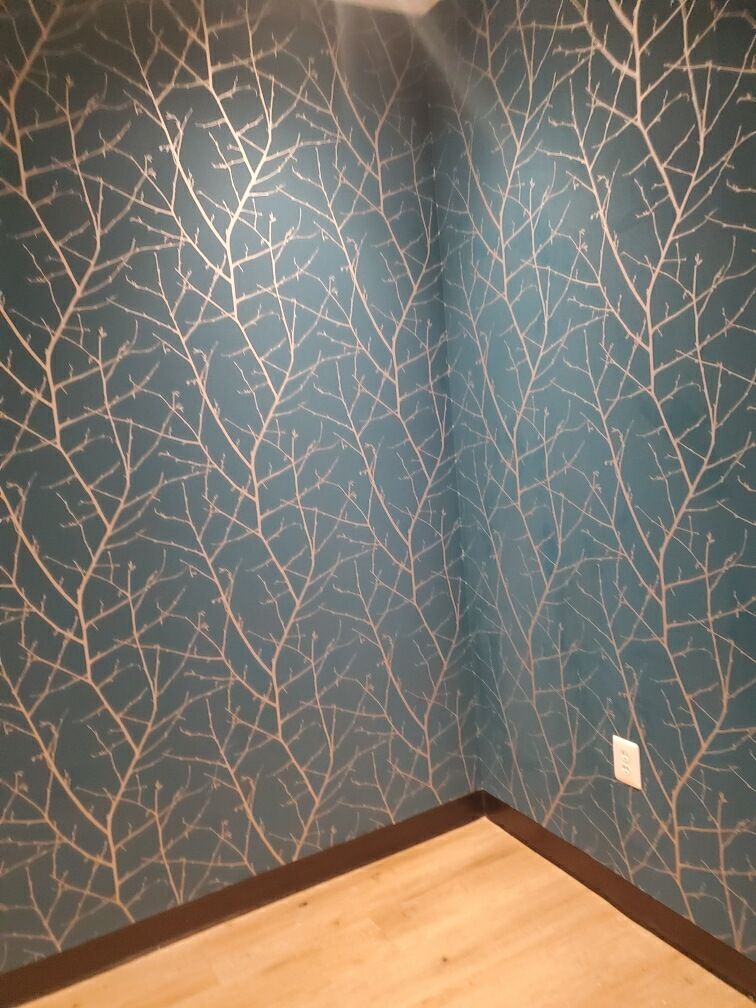 A room with a blue wall and a wooden floor.