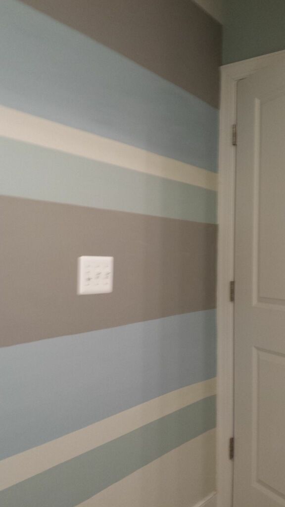 A room with a striped wall and a door.
