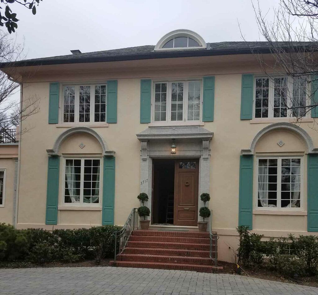 A large house with green shutters on the windows