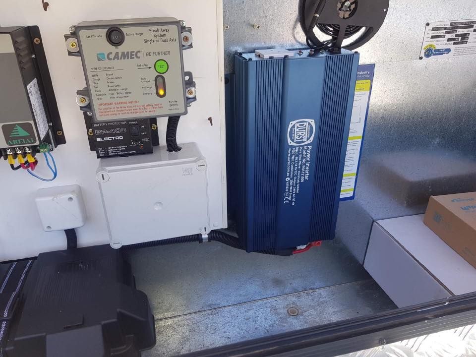 An Indoor Shot of Electronic Equipment Mounted on a White Wall. Includes a Blue Inverter, a Camec Power Control Unit, and Other Components — Shannon's Auto Electrical in Garbutt, QLD