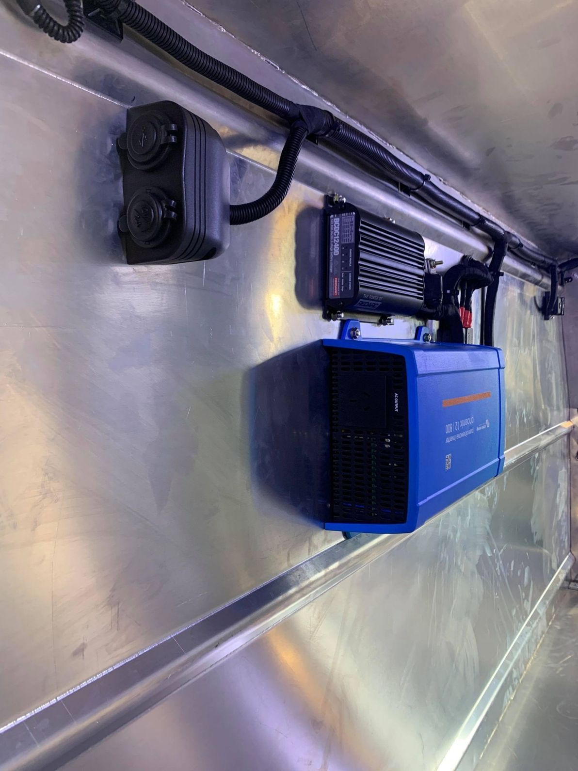 Blue and Black Electronic Equipment Mounted Inside a Vehicle With a Silver Wall — Shannon's Auto Electrical in Garbutt, QLD