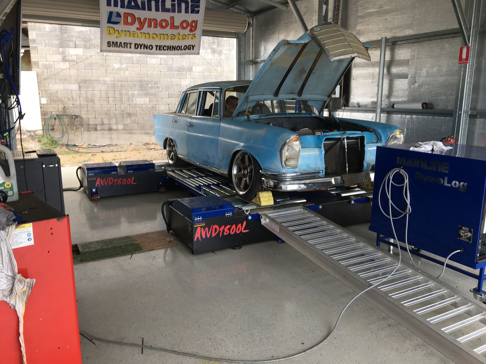Blue Vintage Mercedes on a Dynamometer in a Garage, Testing the Engine Performance. Hood is Open — Shannon's Auto Electrical in Garbutt, QLD