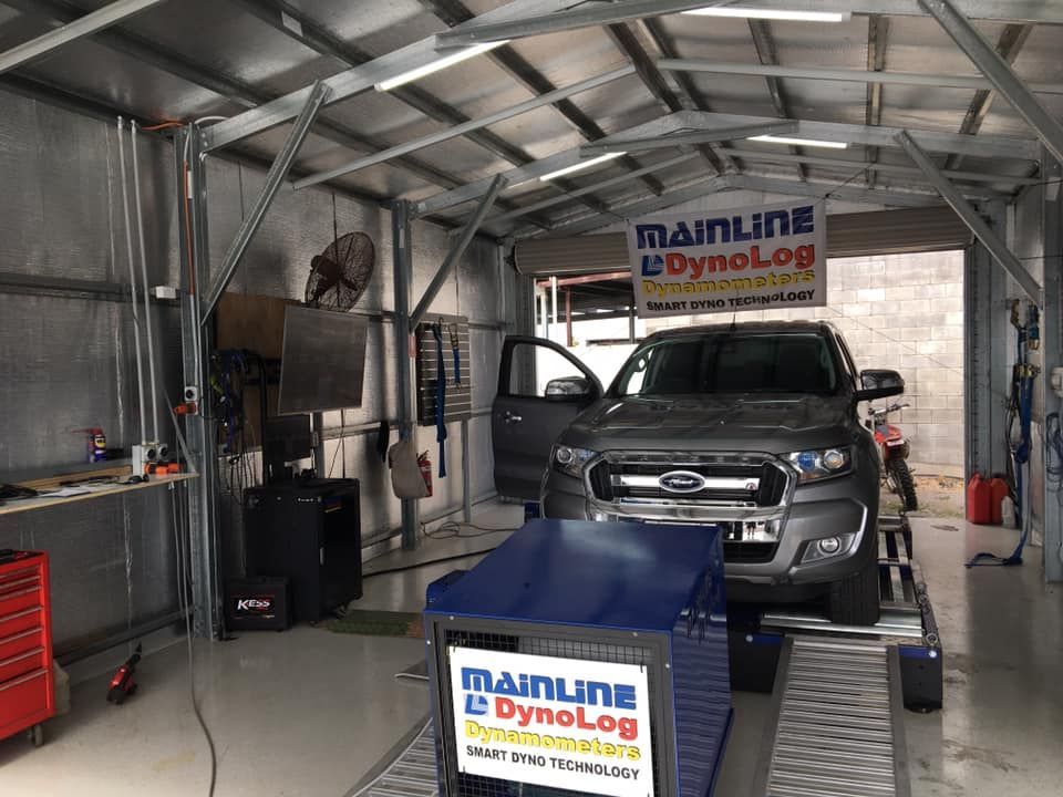 Ford Ranger Truck on a Dyno in a Garage, Being Tested for Performance. the Dyno is Blue, and the Garage is Well-lit — Shannon's Auto Electrical in Garbutt, QLD