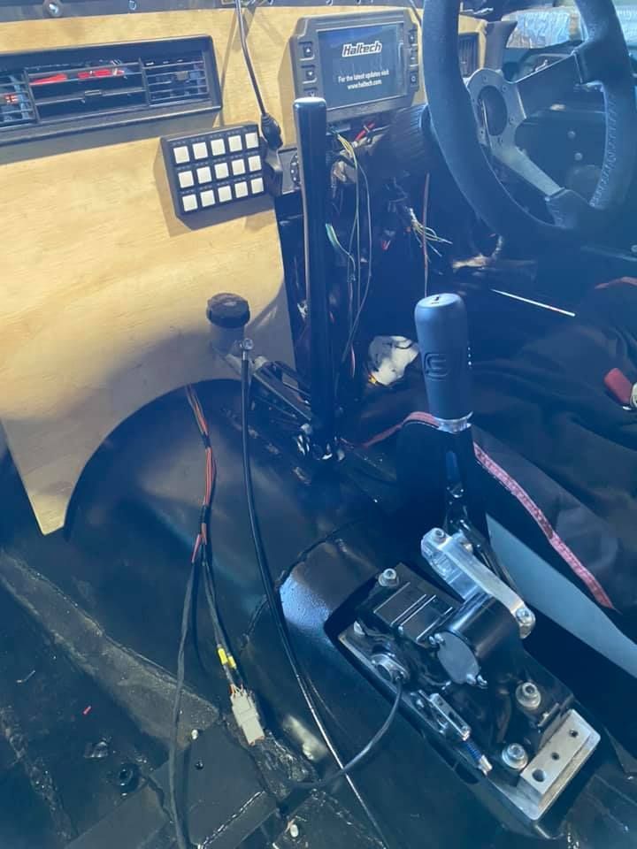 Interior of a Modified Vehicle. Features a Gear Shift, Steering Wheel, and Custom Control Panel With Various Switches. Wires Are Visible — Shannon's Auto Electrical in Garbutt, QLD
