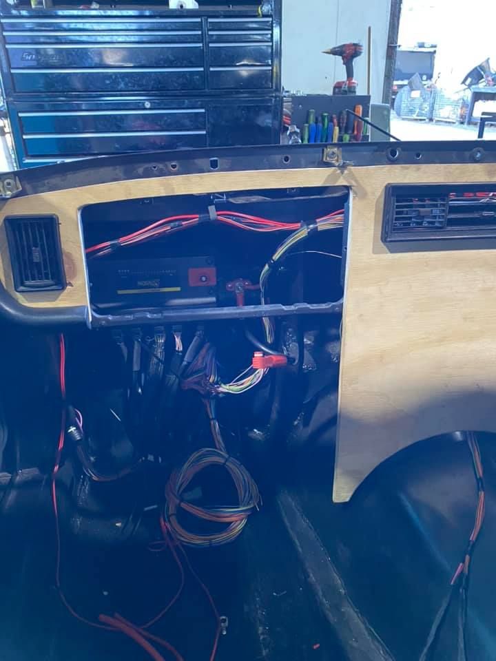 Dashboard Wiring of a Vehicle in Progress, With Wood Paneling and Exposed Wires. Interior Setting With Tools and a Cabinet — Shannon's Auto Electrical in Garbutt, QLD