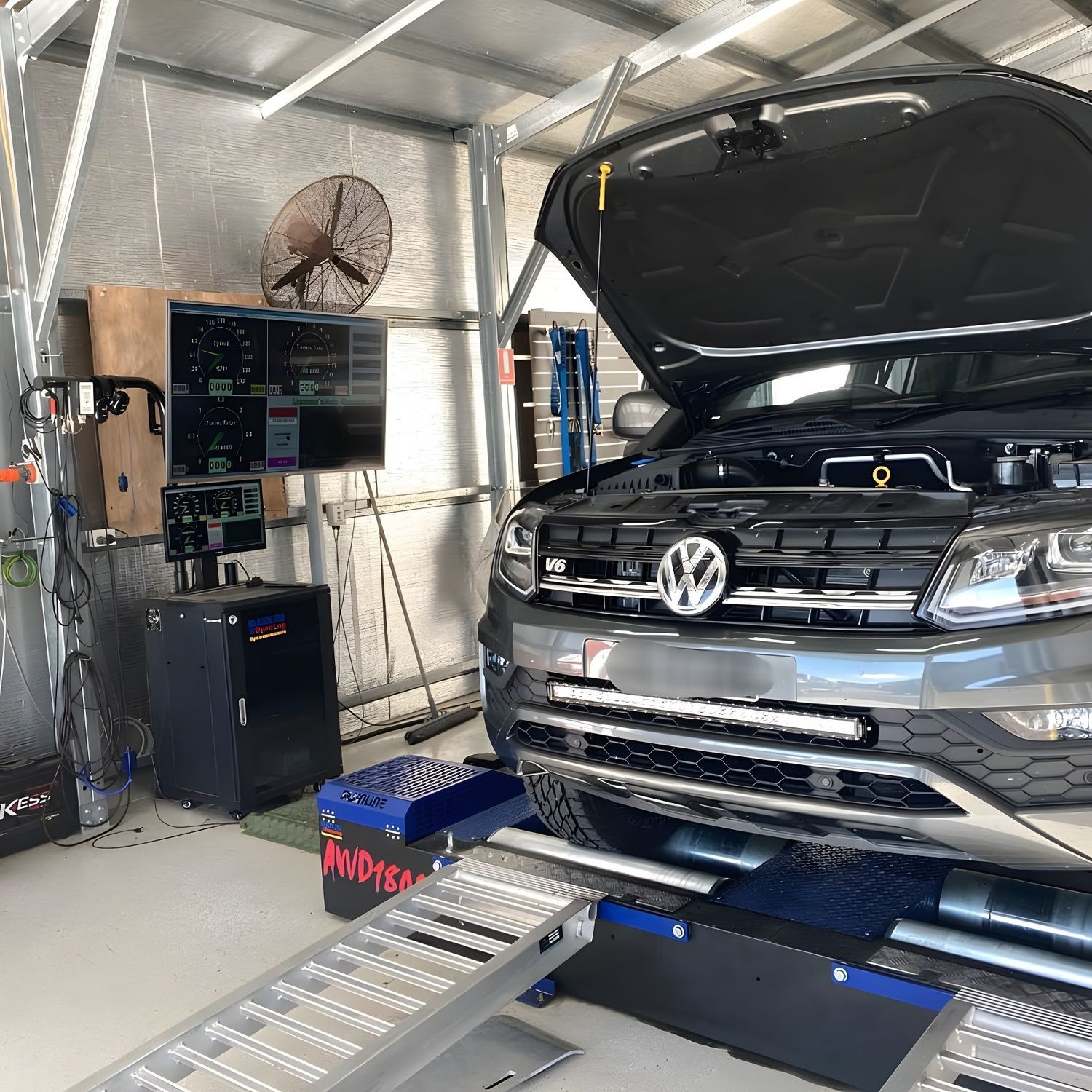 A Volkswagen Truck on a Dynamometer for Tuning. It's in a Garage With Diagnostic Equipment and Monitors, Ready for Testing — Shannon's Auto Electrical in Garbutt, QLD