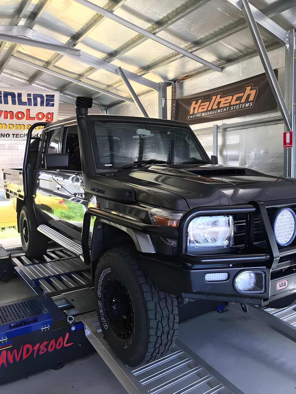 Dark Gray Pickup Truck on a Dynamometer in a Garage, With a Snorkel and Haltech Banner Visible — Shannon's Auto Electrical in Garbutt, QLD