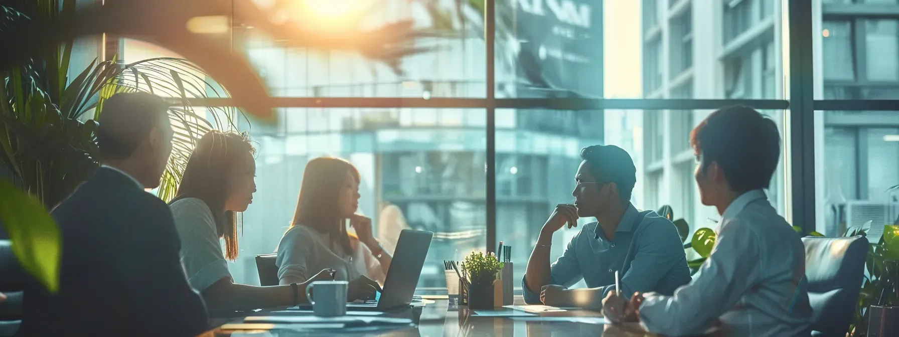 A group of people are sitting around a table having a meeting.