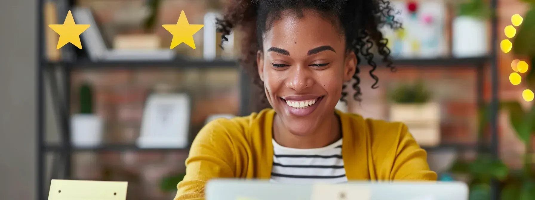 A woman is smiling while using a laptop computer.