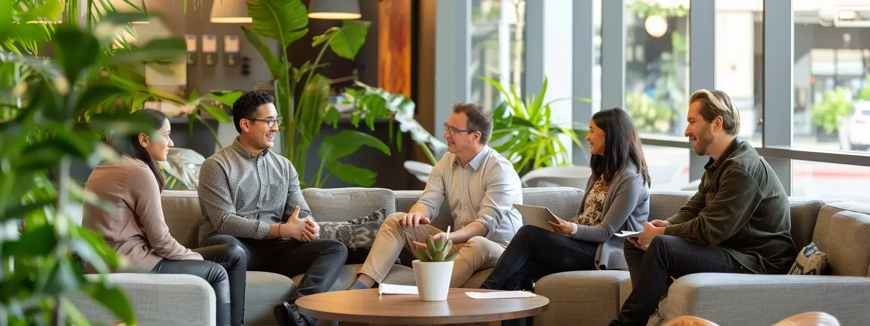 A group of people are sitting around a table in a living room.