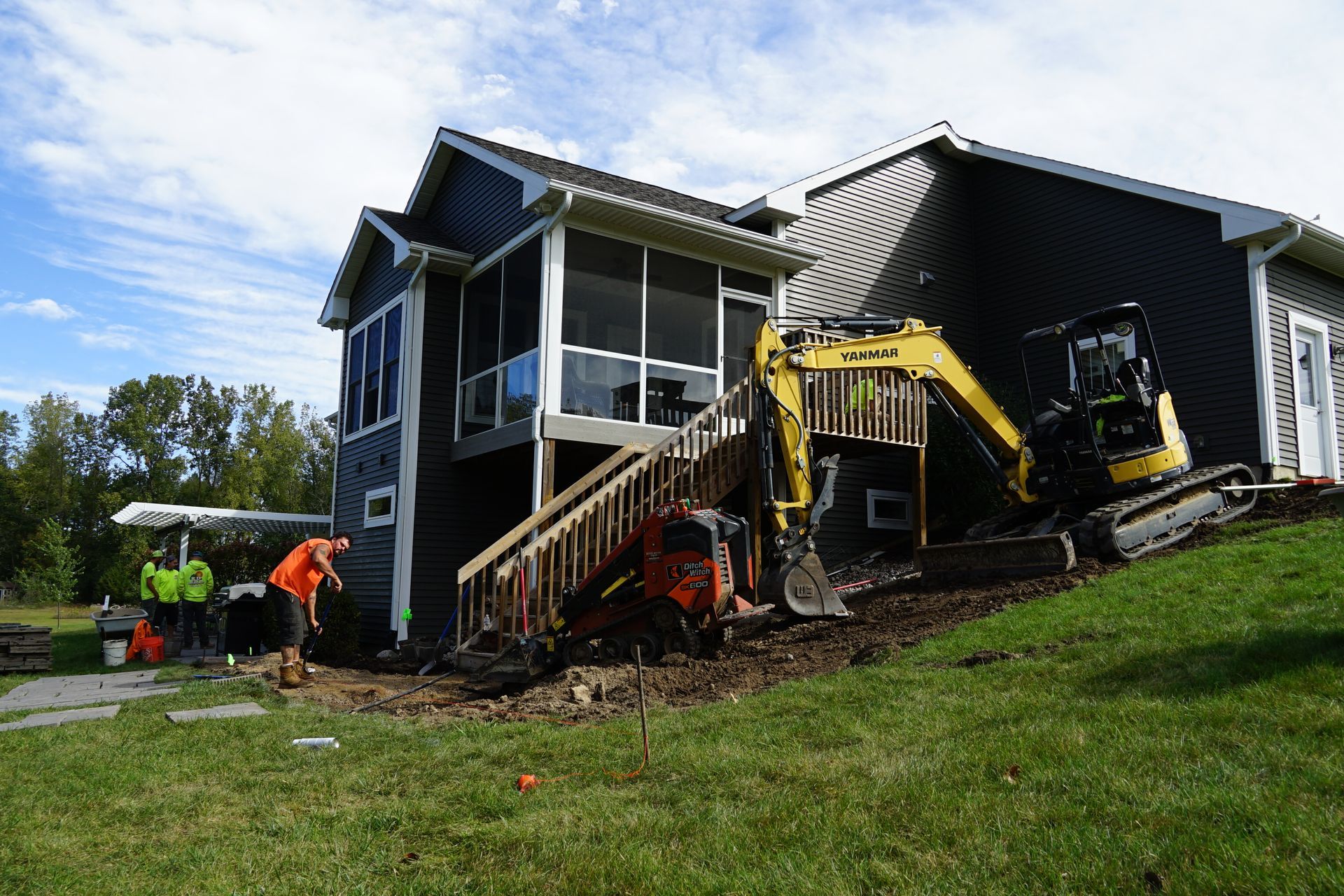 A group of people are working on the side of a house.