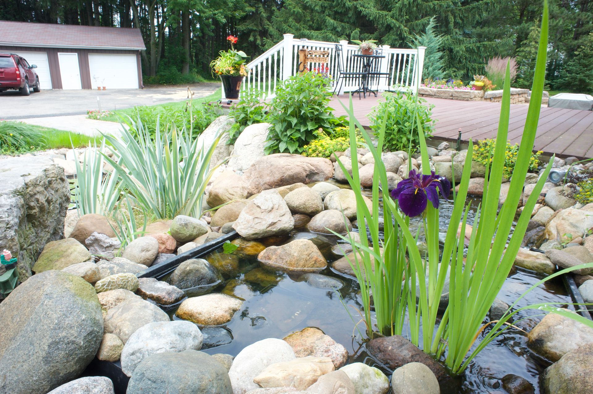 An aerial view of a sprinkler spraying water on a lush green field.