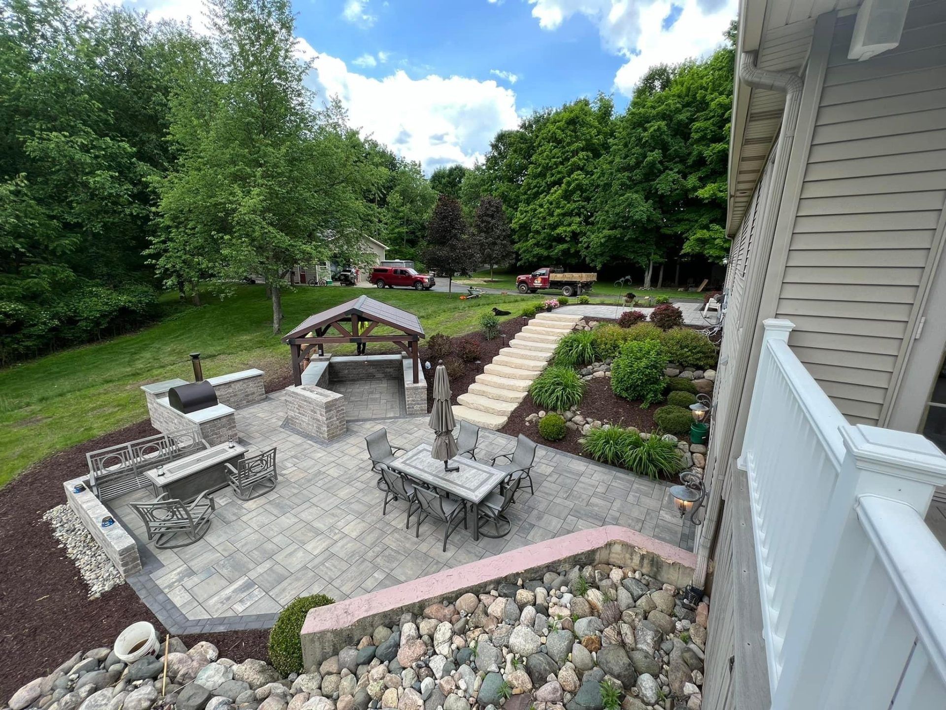 An aerial view of a patio with a table and chairs and a grill.