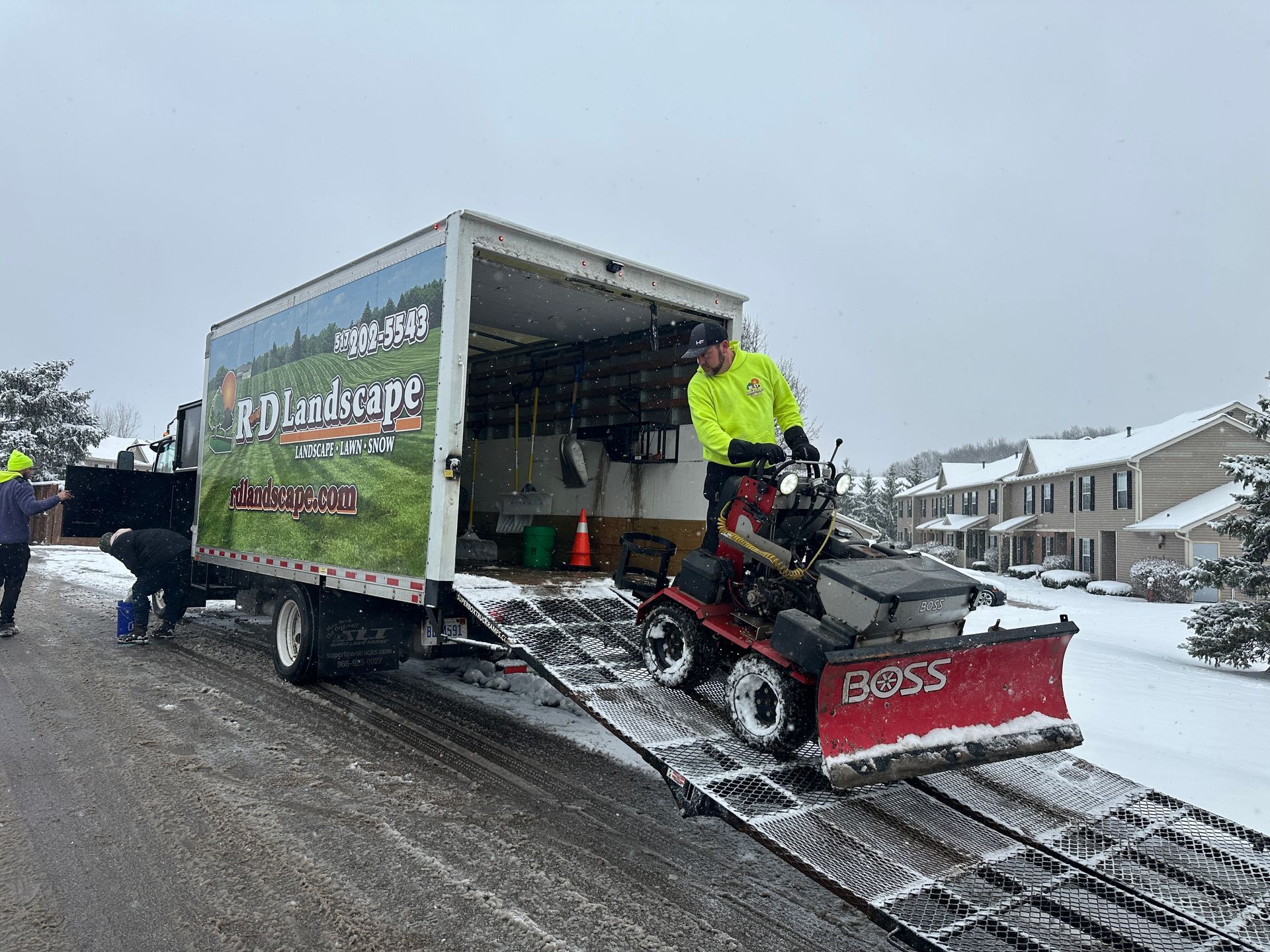 A man is loading a lawn mower into a truck.