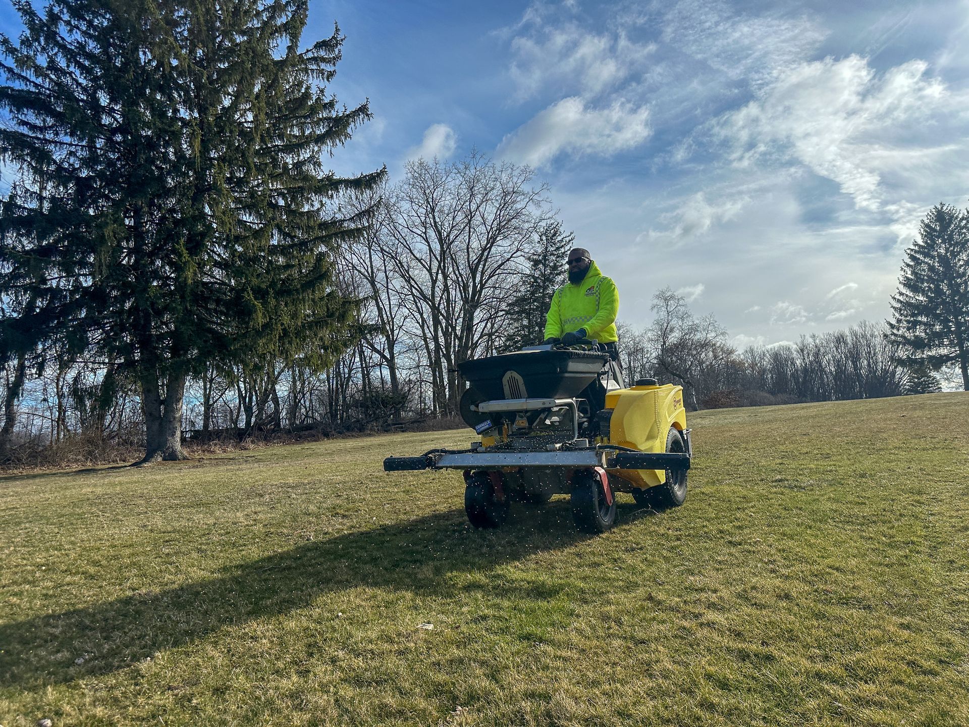 A man is riding a lawn mower in a grassy field.