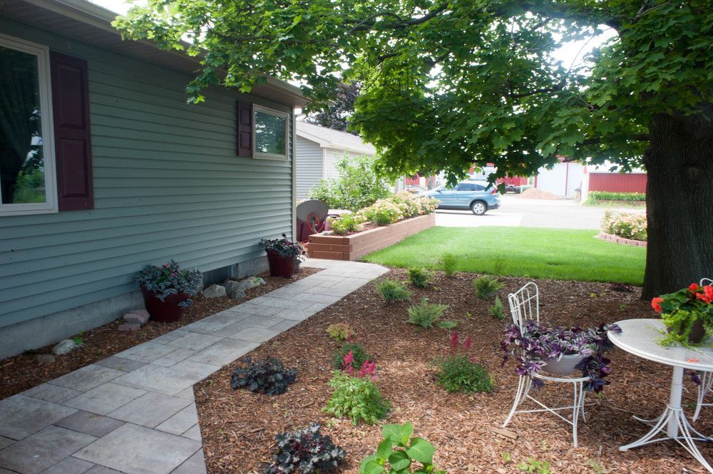 A patio with a table and chairs in front of a house.