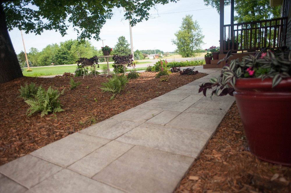 A walkway with a potted plant on the side of it