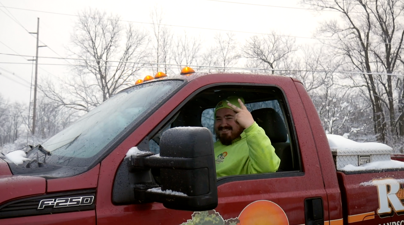 A man is sitting in the driver 's seat of a red truck.