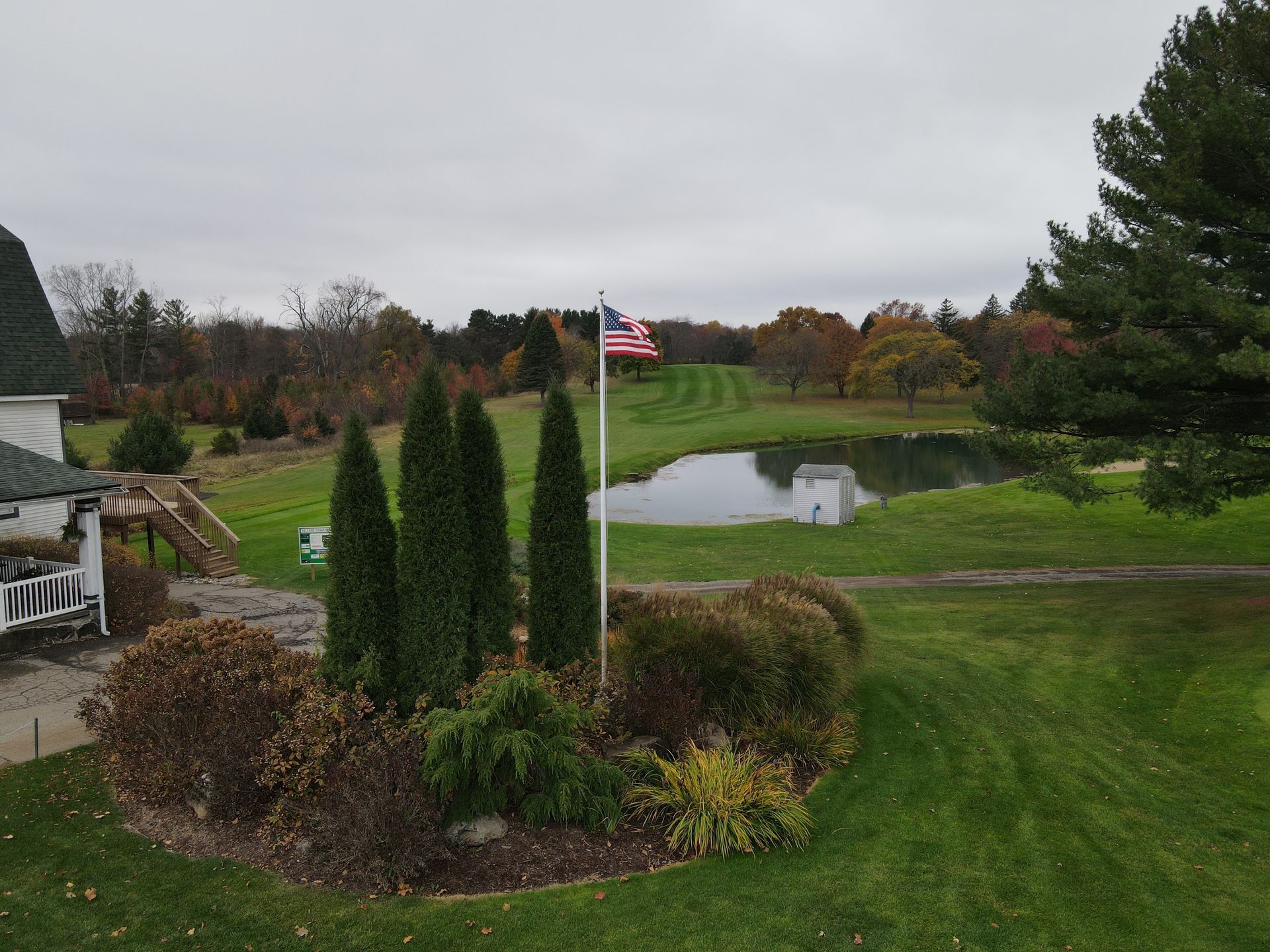 An american flag is flying in front of a pond