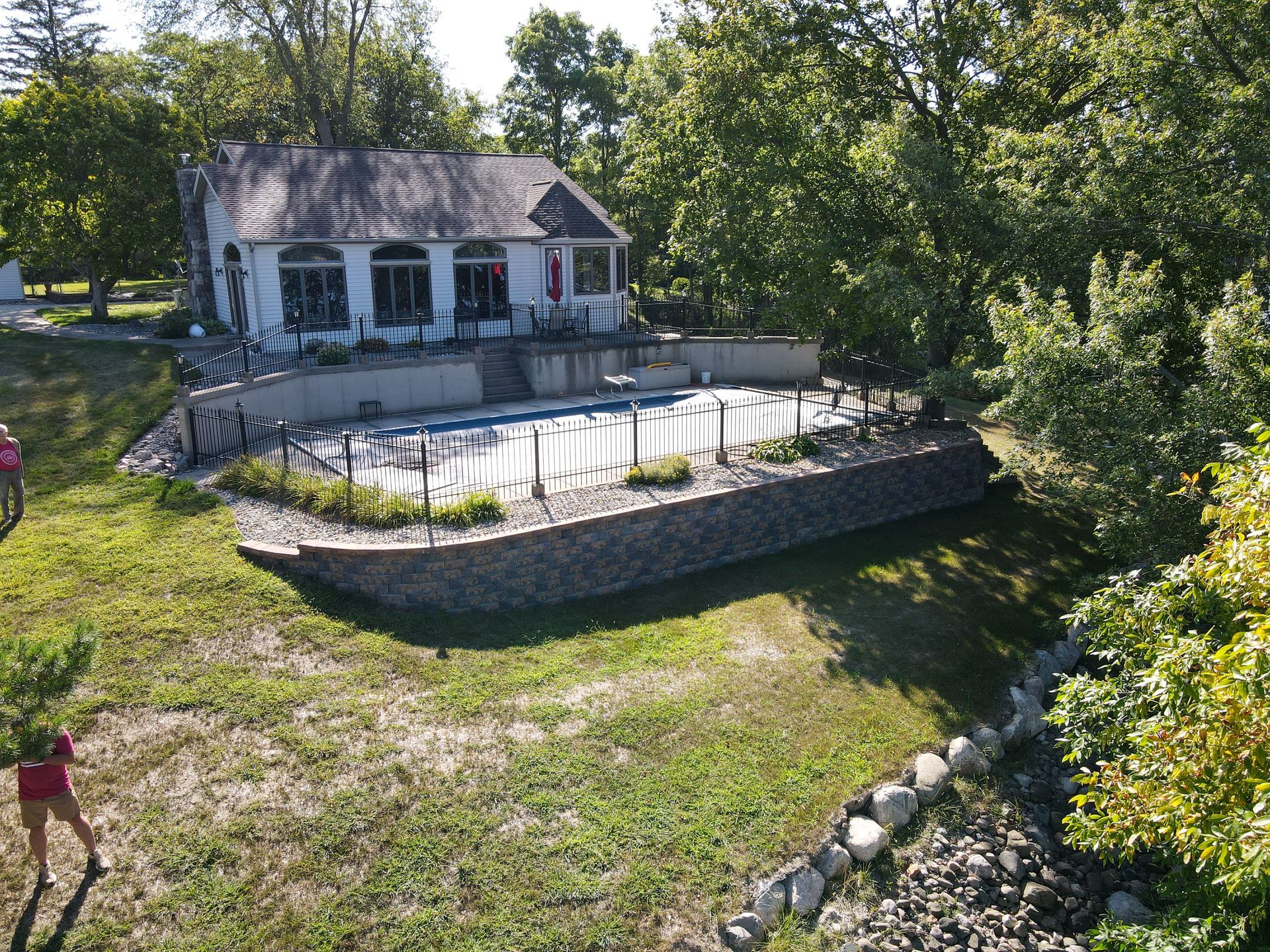 A patio area with a fireplace and a swimming pool at night.
