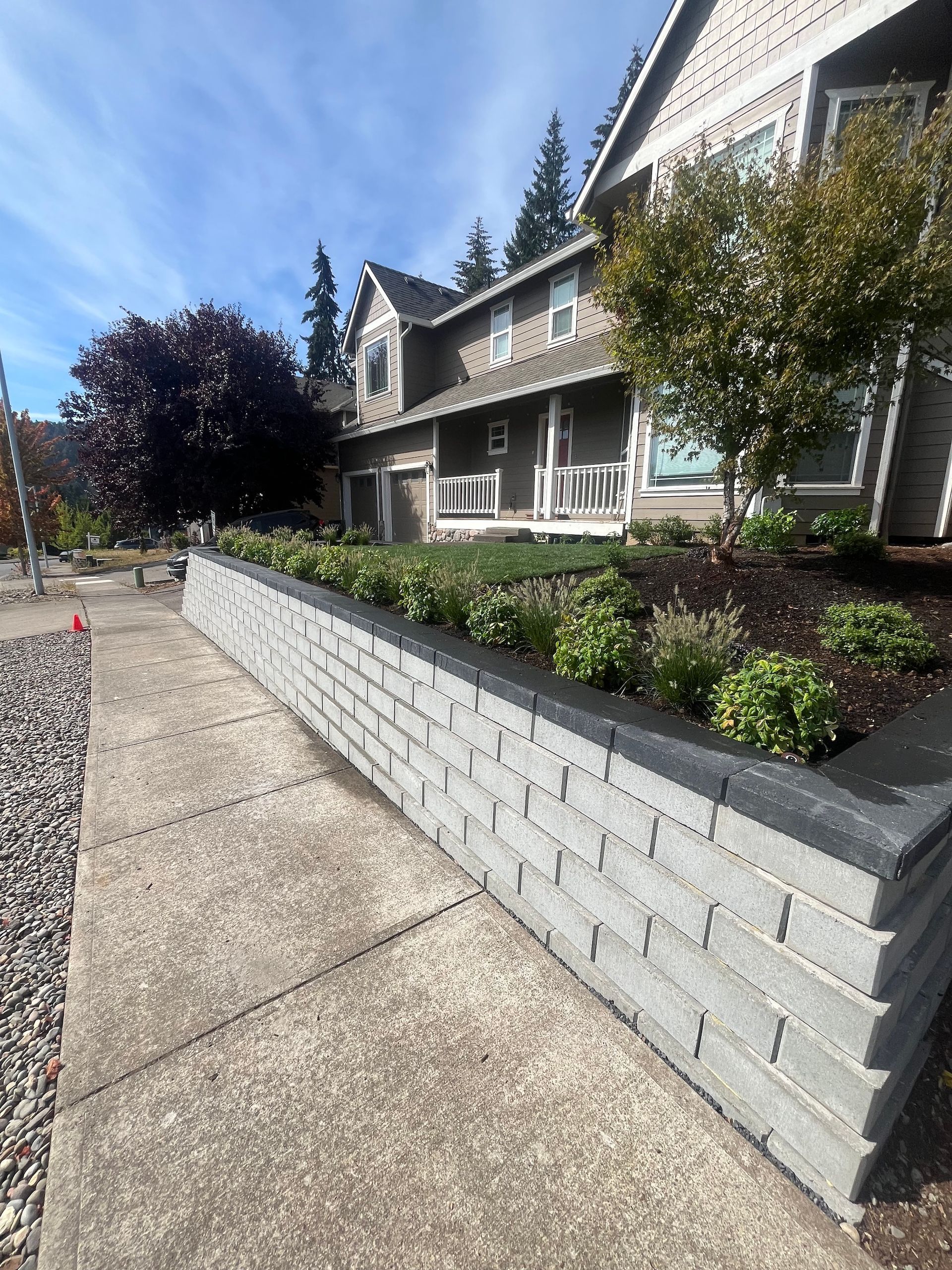 A retaining wall with fresh mulch and plants planted.