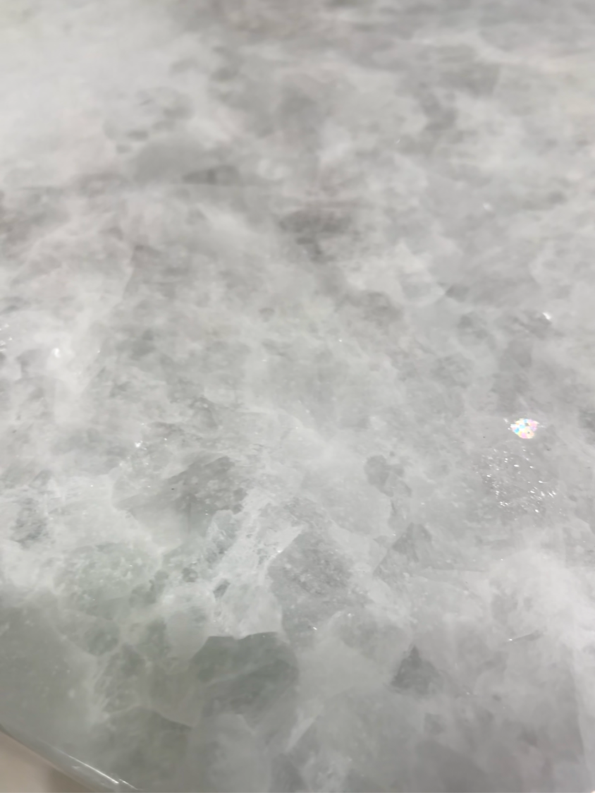 Gray, foamy water churning across a rocky surface, like a close-up of waves or rapids.